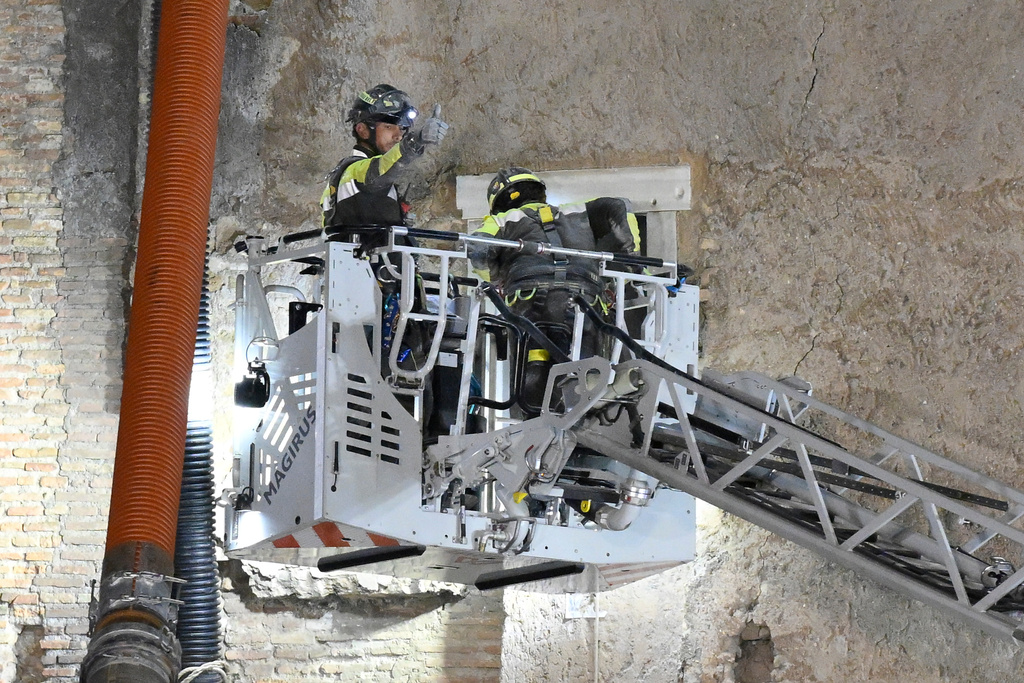 A firefighter gives a thumbs-up as rescuers pull a construction worker from under the debris of a medieval tower that was under renovation near the Roman Forum in Rome, Monday, Nov. 3, 2025, after it partially collapsed earlier in the morning. (Fabrizio Corradetti/LaPresse via AP)