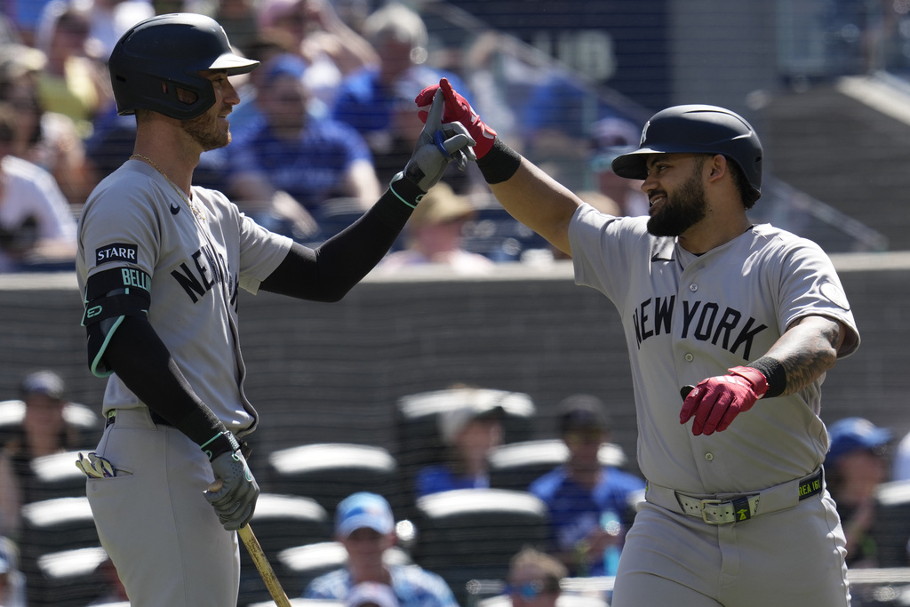 New York Yankees' Jasson Dominguez, right, is congratulated by Cody Bellinger (35) after hitting a solo home run against the Toronto Blue Jays during the fourth inning of a baseball in Toronto, Saturday, June 13, 2026. (Frank Gunn/The Canadian Press via AP)