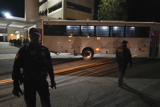 Law enforcement officers line the road outside a United States Immigration and Customs Enforcement (ICE) facility as a bus leaves with passengers on Tuesday, Oct. 21, 2025, in Portland, Ore. (AP Photo/Jenny Kane) Law enforcement officers line the road outside a United States Immigration and Customs Enforcement (ICE) facility as a bus leaves with passengers on Tuesday, Oct. 21, 2025, in Portland, Ore. (AP Photo/Jenny Kane)