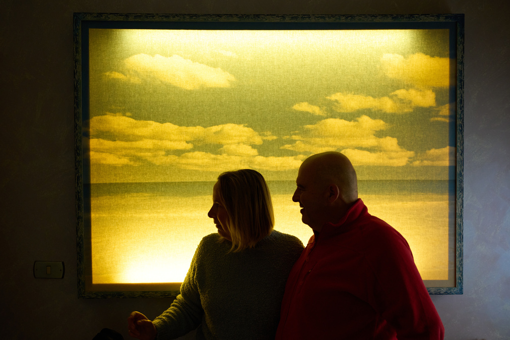 Michela Marcato, left, who is blind, and her partially sighted partner Massimiliano Naccarato, stand in front of a painting representing the sea during an interview at their home in Rome, Monday, Jan. 12, 2026. (AP Photo/Alessandra Tarantino)
