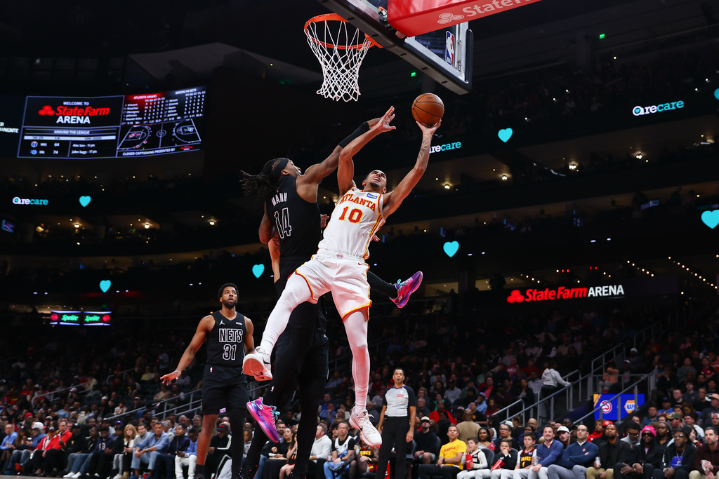 Atlanta Hawks forward Zaccharie Risacher (10) shoots against Brooklyn Nets guard Terance Mann (14) during the first half of an NBA basketball game, Thursday, March 12, 2026, in Atlanta. (AP Photo/Colin Hubbard)