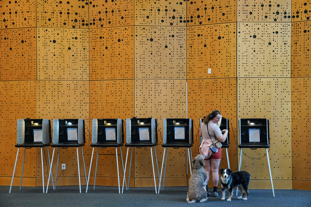 Danielle Grisolano brings her dogs Lincoln and Pepper with her to vote in the Democratic primaries at Denver Public Library, Tuesday, June 30, 2026, in Denver. (AP Photo/Rebecca Slezak)