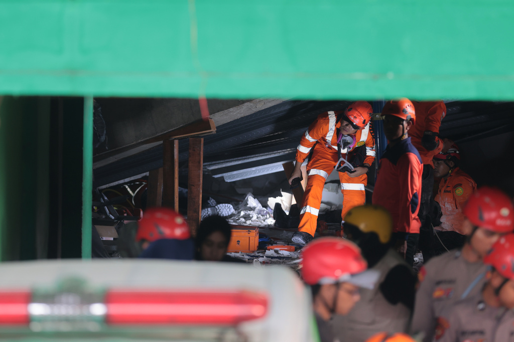 Rescuers search for victims after a building under construction collapsed, at an Islamic boarding school in Sidoarjo, East Java, Indonesia, Tuesday, Sept. 30, 2025. (AP Photo/Trisnadi)
