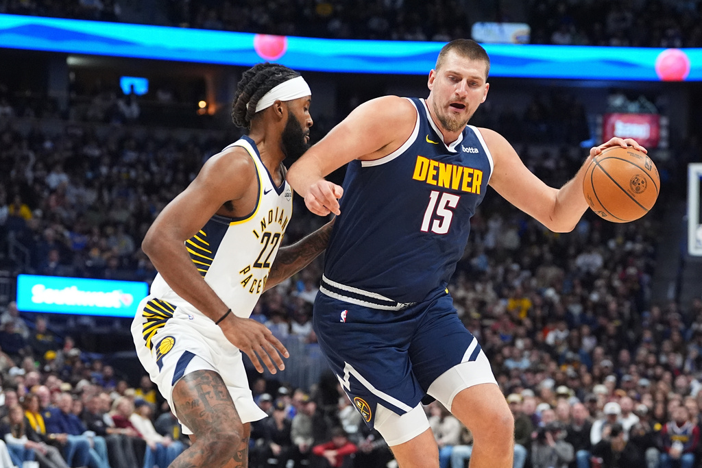 Denver Nuggets center Nikola Jokić, right, drives the lane as Indiana Pacers forward Isaiah Jackson defends in the first half of an NBA basketball game, Saturday, Nov. 8, 2025, in Denver. (AP Photo/David Zalubowski)