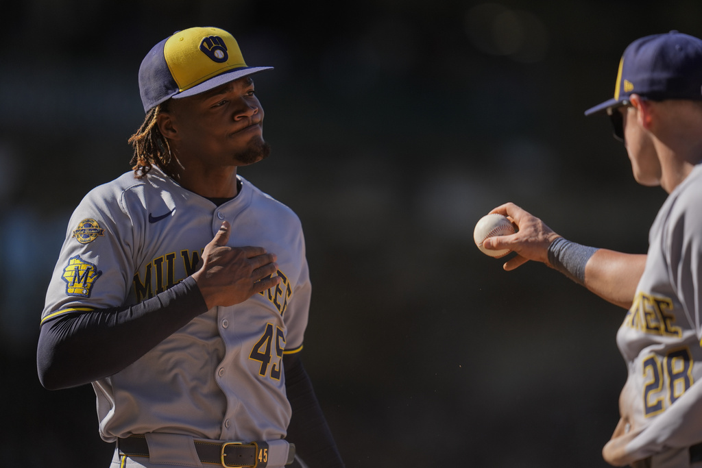 Milwaukee Brewers pitcher Abner Uribe, left, reacts after first baseman Andrew Vaughn (28) forced out Chicago Cubs' Owen Caissie to end the eighth inning of a baseball game Thursday, Aug. 21, 2025, in Chicago. (AP Photo/Erin Hooley)