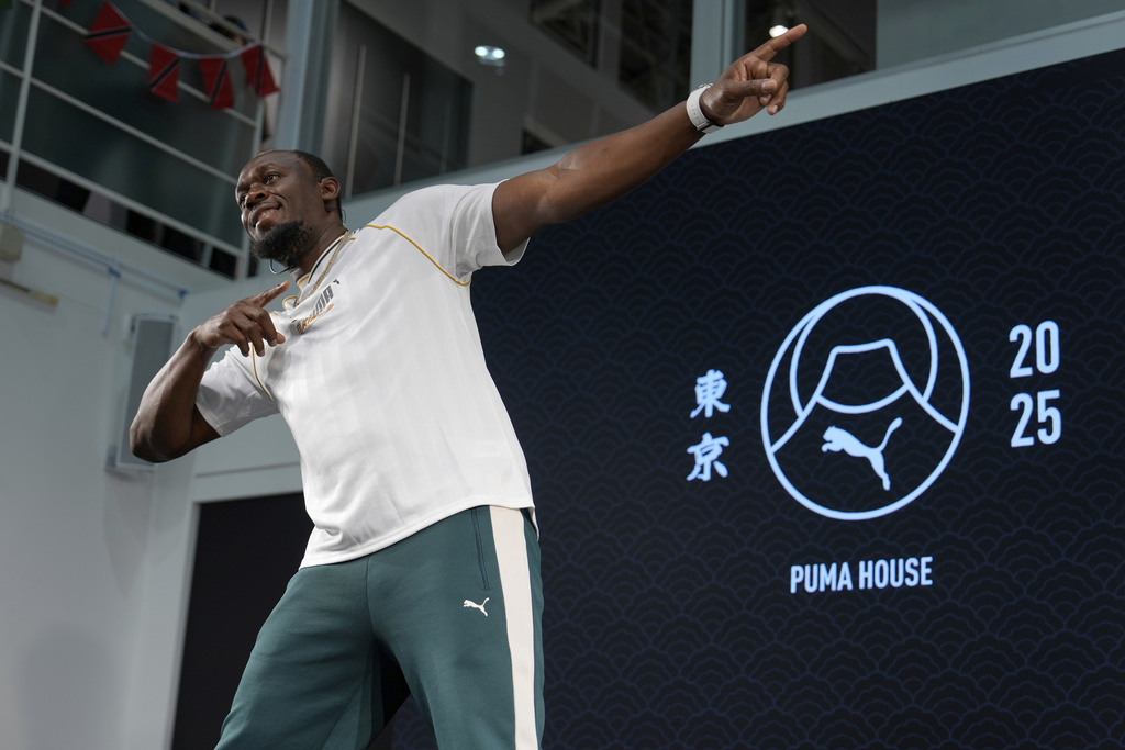 Former sprinter, Jamaica's Usain Bolt makes his signature pose at the end of a press conference ahead of the World Athletics Championships in Tokyo, Japan, Thursday, Sept. 11, 2025. (AP Photo/Eugene Hoshiko)
