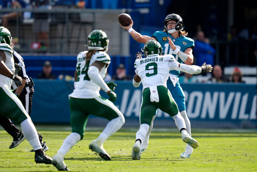 Jacksonville Jaguars quarterback Trevor Lawrence (16) looks to pass the ball against New York Jets defensive end Will McDonald IV (9) during the first half of an NFL football game, Sunday, Dec. 14, 2025, in Jacksonville, Fla. (AP Photo/John Raoux)