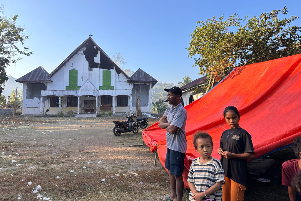 Earthquake survivors stand outside their tent erected near a damaged church in Satar Punda, East Nusa Tenggara province, Indonesia, Tuesday, Aug. 18, 2026. (AP Photo/Firdia Lisnawati)