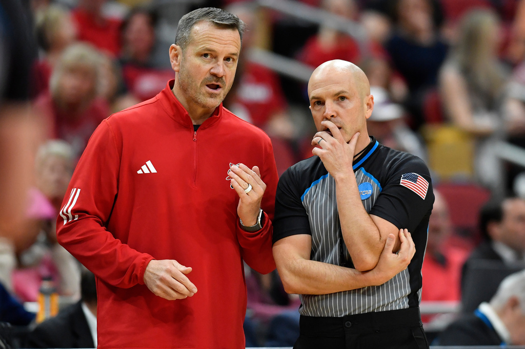 Louisville head coach Jeff Walz, left, discusses a call with a referee during the second half against Virginia in the first round of the NCAA college basketball tournament, Saturday, March 21, 2026 in Louisville, Ky. (AP Photo/Timothy D. Easley)
