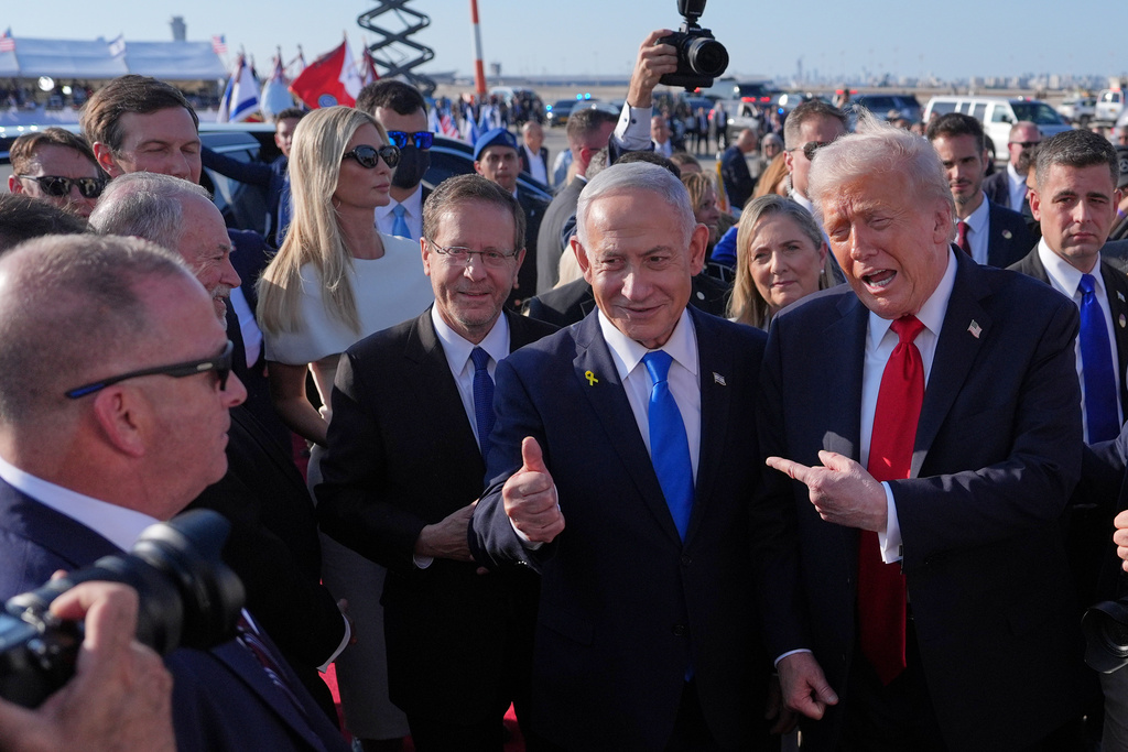 President Donald Trump poses for a photo with Israel's Prime Minister Benjamin Netanyahu before he boards Air Force One at Ben Gurion International Airport, Monday, Oct. 13, 2025, near Tel Aviv, as Israel's President Isaac Herzog, left, watches. (AP Photo/Evan Vucci)