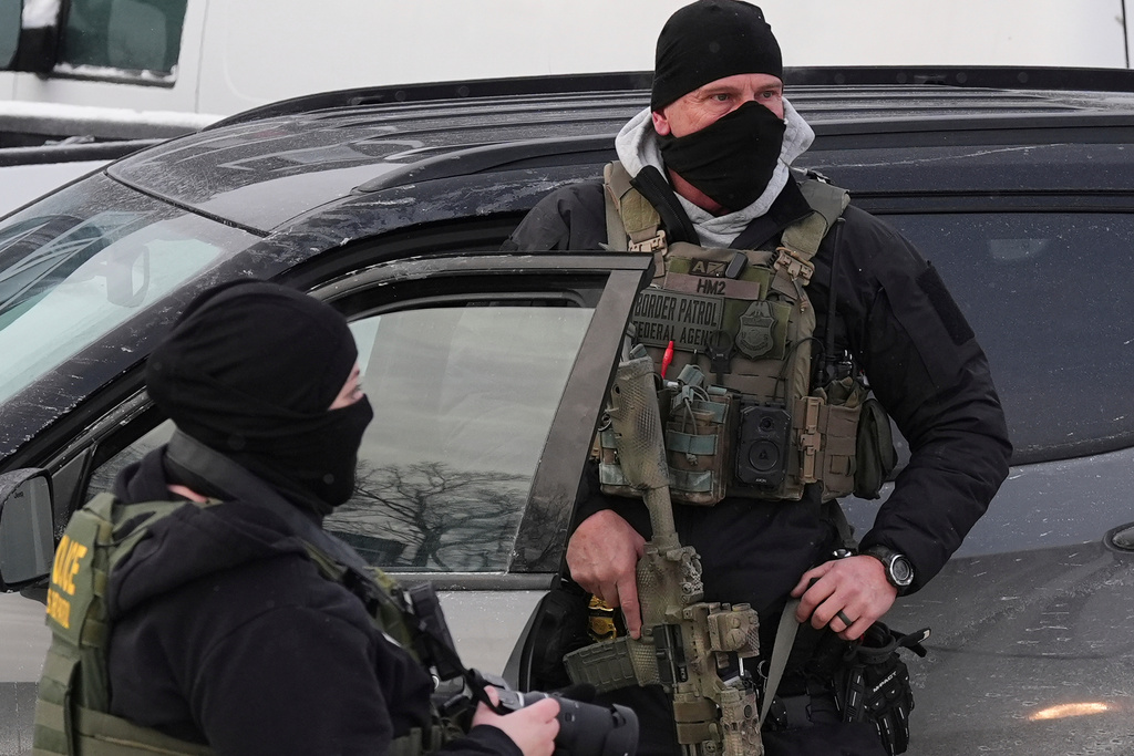 Federal immigration agents work on the scene in Minneapolis, Sunday, Jan. 25, 2026. (AP Photo/Adam Gray)