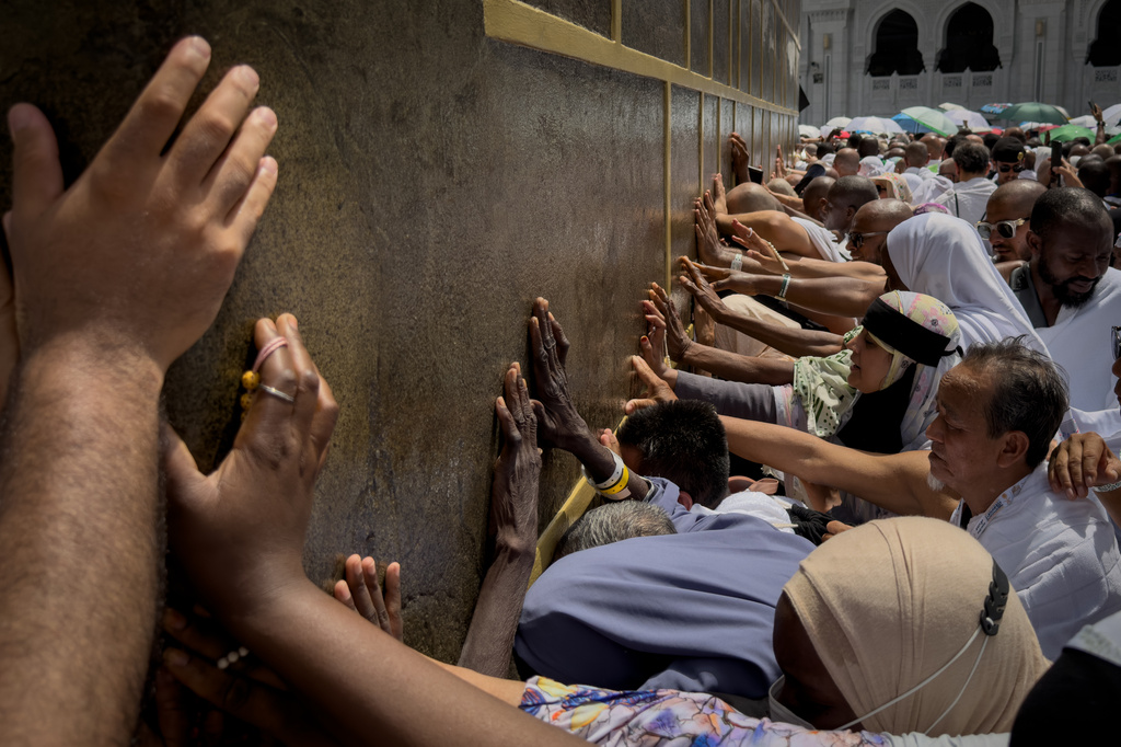 Muslim pilgrims touch the walls of the Kaaba, the cubic building at the Grand Mosque, during the annual Hajj pilgrimage, in Mecca, Saudi Arabia, Thursday, May 21, 2026. (AP Photo/Altaf Qadri)