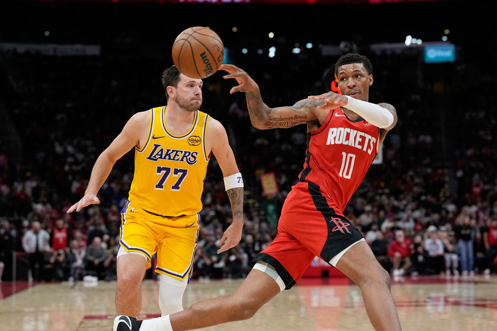 Houston Rockets' Jabari Smith Jr. (10) passes the ball as Los Angeles Lakers' Luka Doncic (77) defends during the second half of an NBA basketball game Monday, March 16, 2026, in Houston. (AP Photo/David J. Phillip)