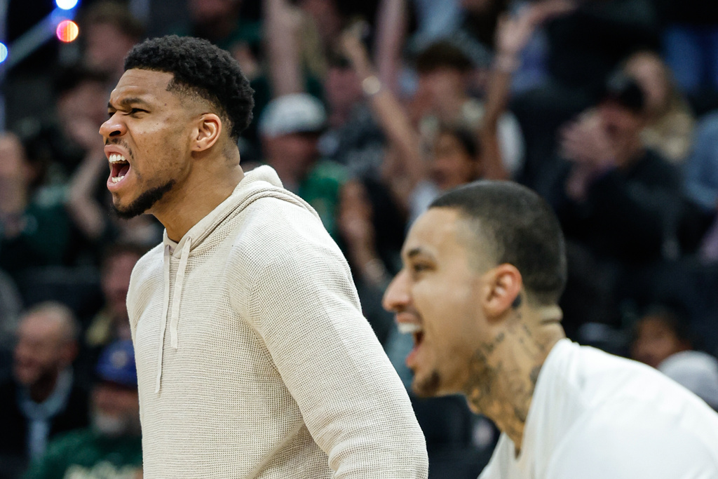 Milwaukee Bucks forward Giannis Antetokounmpo, left and Kyle Kuzma react after teammate AJ Green made a three-pointer against the Brooklyn Nets during an NBA basketball game, Friday, April 10, 2026, in Milwaukee. (AP Photo/Jeffrey Phelps)
