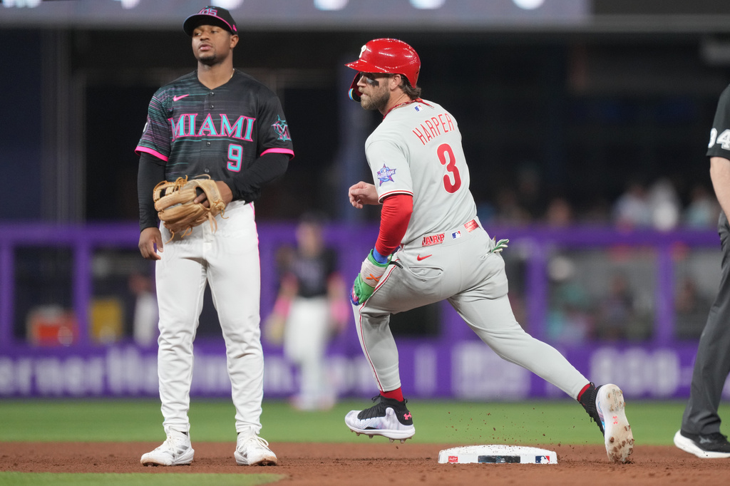 Philadelphia Phillies' Bryce Harper (3) steals second base as Miami Marlins second baseman Xavier Edwards (9) looks on in the fifth inning of a baseball game, Friday, May 1, 2026, in Miami. (AP Photo/Jim Rassol)