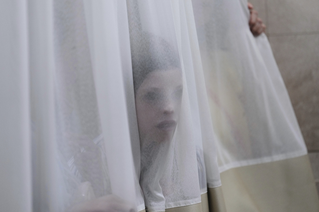 A mourner looks trough a curtain during the funeral of Levi Yitzhak Pash, who was killed along with five other Israelis in a shooting attack by two Palestinian gunmen at a bus stop in Jerusalem Monday, Sept. 8, 2025. (AP Photo/Ariel Schalit)