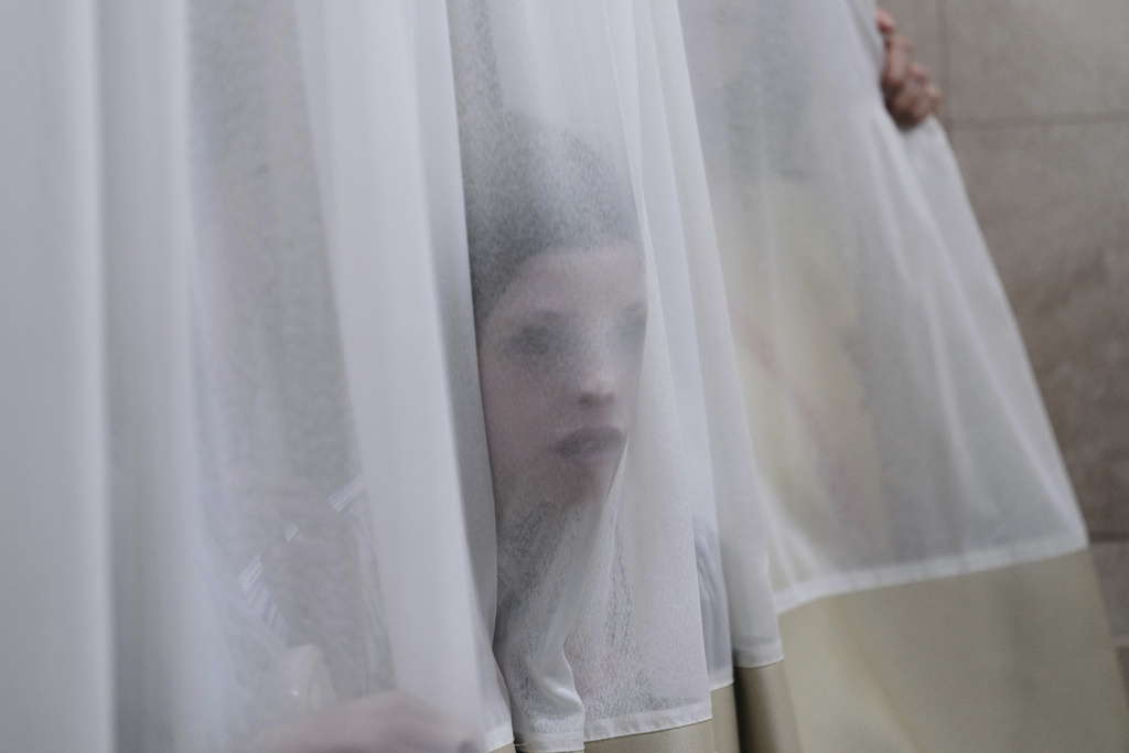 A mourner looks trough a curtain during the funeral of Levi Yitzhak Pash, who was killed along with five other Israelis in a shooting attack by two Palestinian gunmen at a bus stop in Jerusalem Monday, Sept. 8, 2025. (AP Photo/Ariel Schalit)