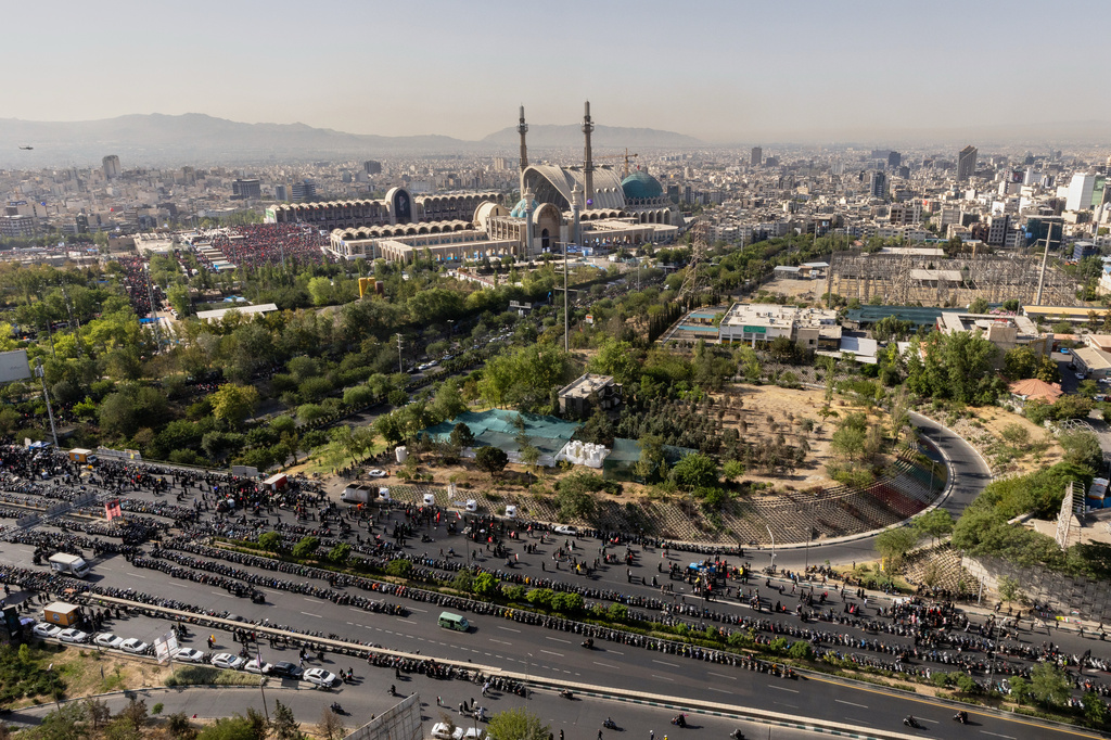 Mourners pray on a road adjacent to the Imam Khomeini Mosalla Grand Mosque, top, during funeral ceremonies for the slain Iranian Supreme Leader Ayatollah Ali Khamenei and members of his family in Tehran, Iran, Sunday, July 5, 2026. (Hadi Zand/ISNA via AP)