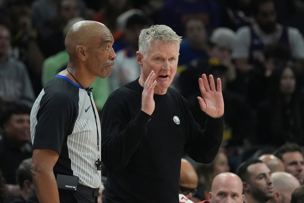Golden State Warriors head coach Steve Kerr, right, argues with referee Leon Wood, left, during the first half of an NBA basketball game against the Phoenix Suns Thursday, Dec. 18, 2025, in Phoenix. (AP Photo/Ross D. Franklin)
