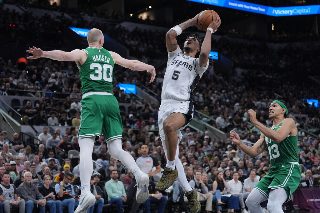 San Antonio Spurs guard Stephon Castle (5) drives to the basket against Boston Celtics forward Sam Hauser (30) during the second half of an NBA basketball game in San Antonio, Tuesday, March 10, 2026. (AP Photo/Eric Gay)