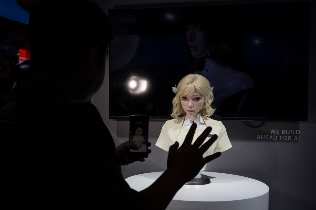 A lifelike robot head looks at a visitor during the World AI Conference in Shanghai, Friday, July 17, 2026. (AP Photo/Ng Han Guan)
