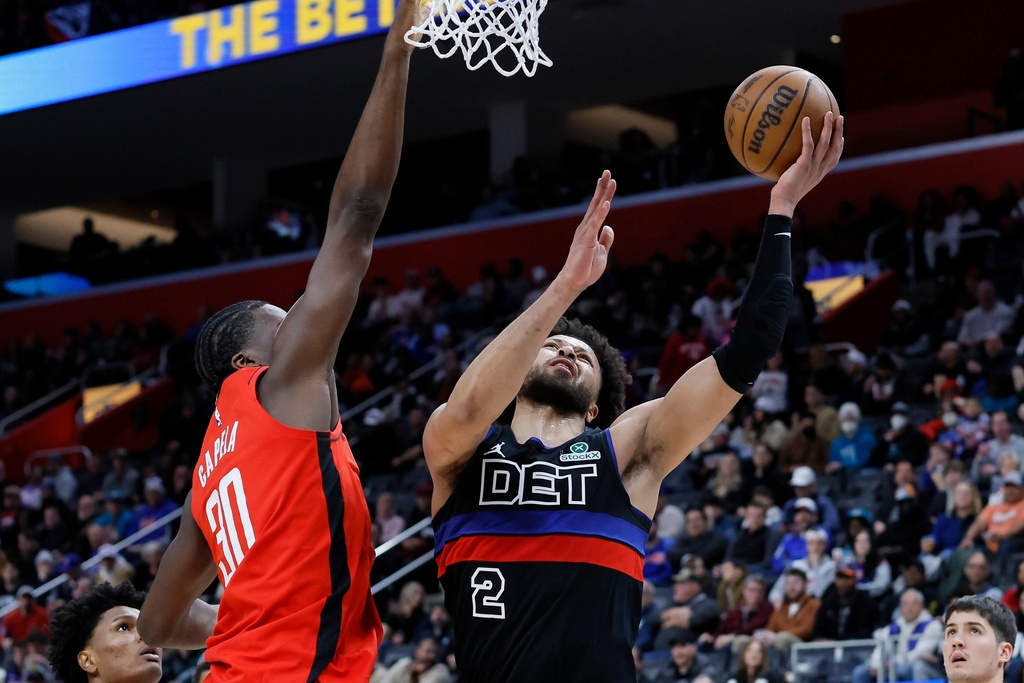 Detroit Pistons guard Cade Cunningham (2) lays up a shot against Houston Rockets center Clint Capela (30) during the first half of an NBA basketball game Friday, Jan. 23, 2026, in Detroit. (AP Photo/Duane Burleson)