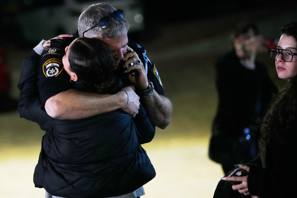 A police officer hugs a family member of Israeli hostage Ran Gvili after the announcement that his remains were the last to be recovered from Gaza, at his home in the village of Meitar, southern Israel, Monday, Jan. 26, 2026. (AP Photo/Ohad Zwigenberg)