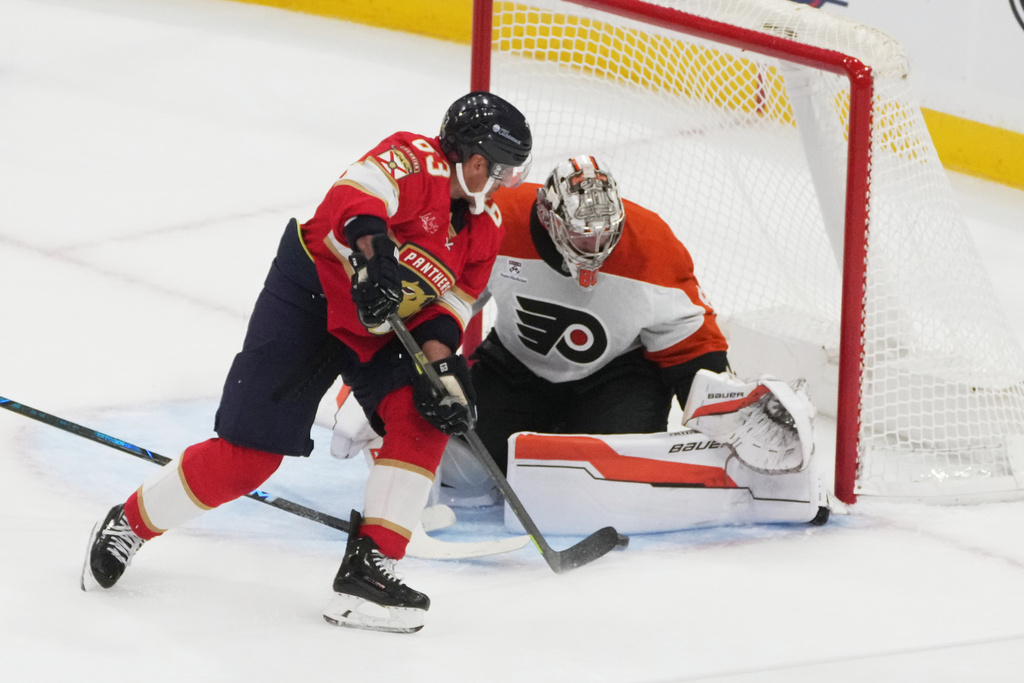 Philadelphia Flyers goaltender Dan Vladar (80) stops a shot by Florida Panthers left wing Brad Marchand (63) during the second period of an NHL hockey game, Thursday, Oct. 9, 2025, in Sunrise, Fla. (AP Photo/Marta Lavandier)
