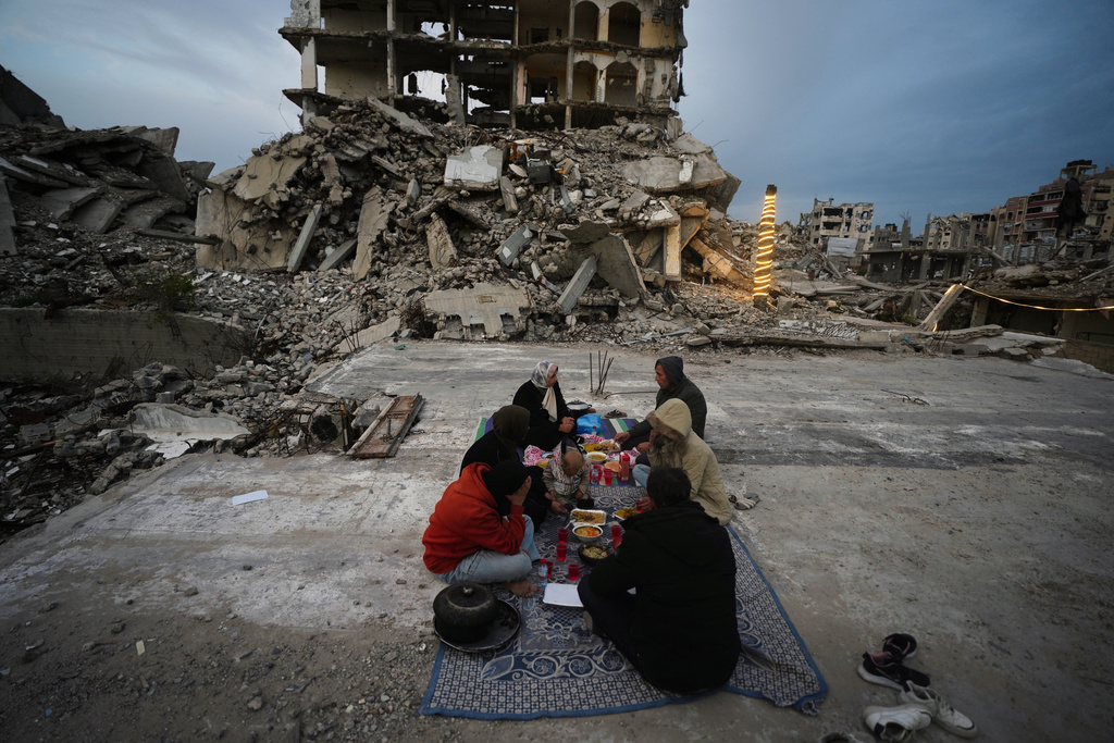 Members of the Al-Najar family break their fast during the Muslim holy month of Ramadan amid the rubble of destroyed buildings in Gaza City Friday, March 13, 2026. (AP Photo/Jehad Alshrafi)