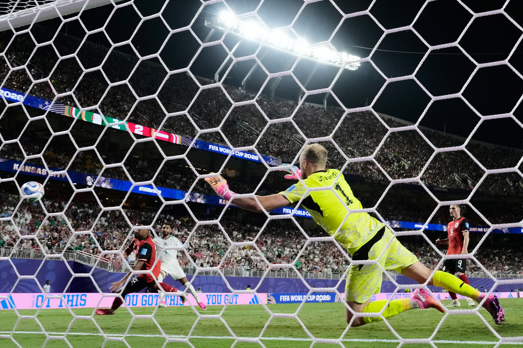 Algeria's Riyad Mahrez (7) scores their second goal past Austria goalkeeper Alexander Schlager (1) during the World Cup Group J soccer match between Algeria and Austria in Kansas City, Mo., Saturday, June 27, 2026. (AP Photo/Charlie Riedel)