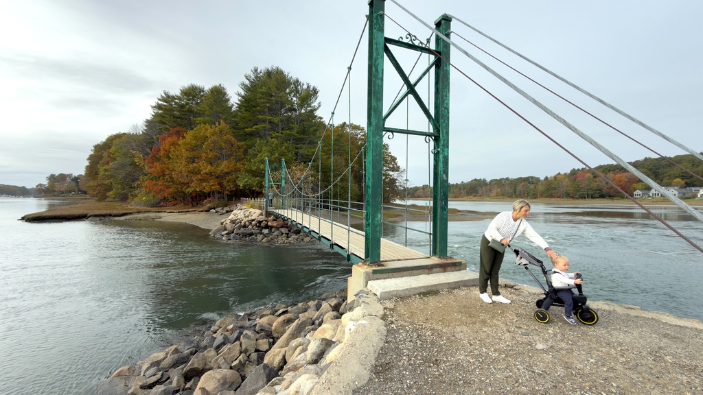 Visitors walk on Wiggly Bridge in York, Maine, on their way to view fall foliage on Tuesday, Oct. 14, 2025. (AP Photo/Rodrique Ngowi)