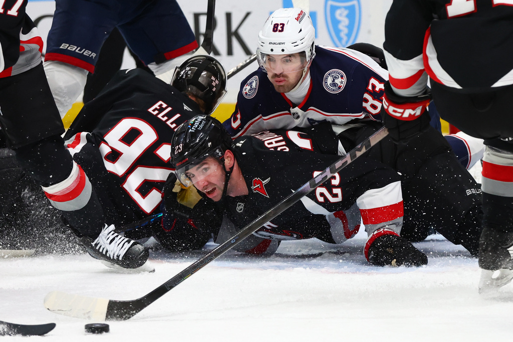 Columbus Blue Jackets right wing Conor Garland (83) and Buffalo Sabres defenseman Mattias Samuelsson (23) watch the puck during the second period of an NHL hockey game Thursday, April 9, 2026, in Buffalo, N.Y. (AP Photo/Jeffrey T. Barnes)