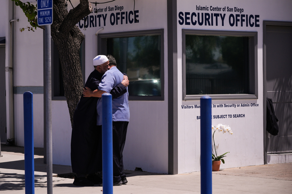 People embrace outside the security office of the Islamic Center of San Diego, a day after a shooting, Tuesday, May 19, 2026, in San Diego. (AP Photo/Jae C. Hong)