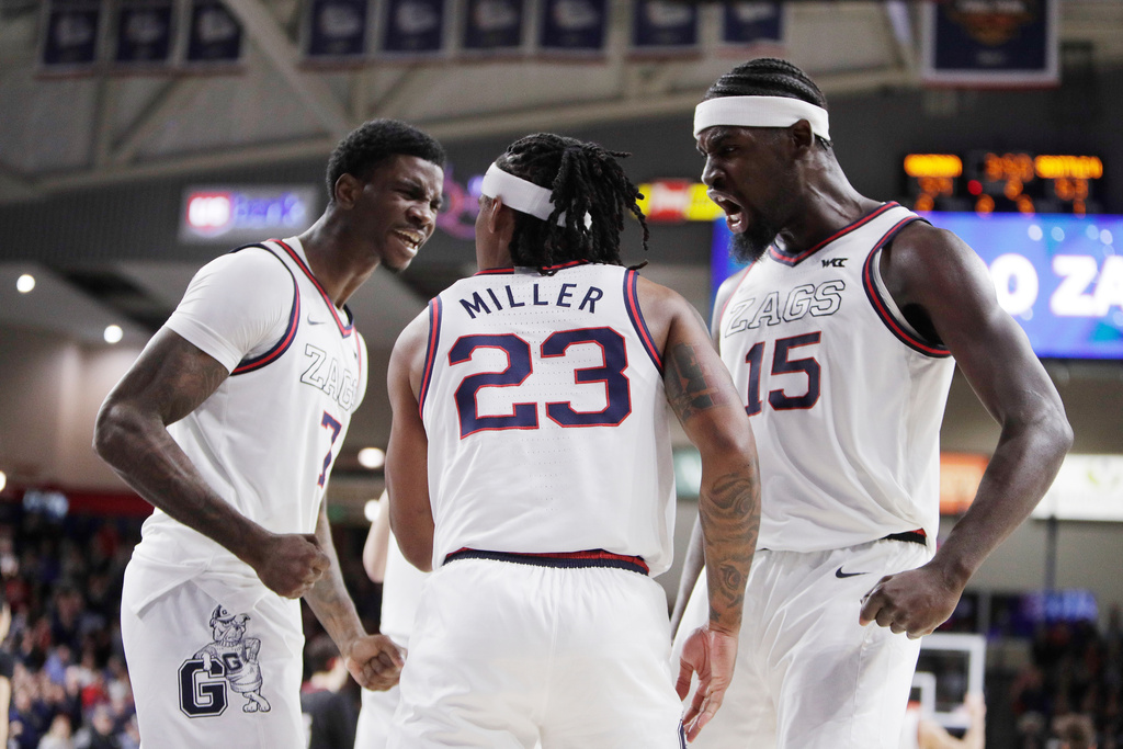 Gonzaga guard Adam Miller (23) celebrates drawing a foul with teammate Tyon Grant-Foster (7) and Graham Ike (15) during the second half of an NCAA college basketball game against Seattle, Friday, Jan. 2, 2026, in Spokane, Wash. (AP Photo/Young Kwak)