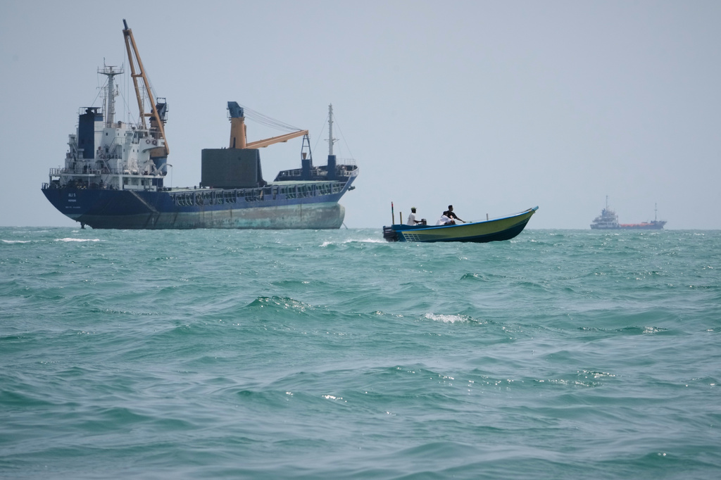 A motorboat passes a general cargo ship anchored in the Strait of Hormuz off Bandar Abbas, Iran, Sunday, Sept. 6, 2026. (AP Photo/Vahid Salemi)