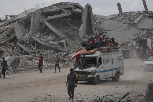 Displaced Palestinians ride on a van loaded with their belongings amid rubble in Gaza City, Sunday, Oct. 12, 2025, after Israel and Hamas agreed to a pause in their war and the release of the remaining hostages. (AP Photo/Abdel Kareem Hana) Displaced Palestinians ride on a van loaded with their belongings amid rubble in Gaza City, Sunday, Oct. 12, 2025, after Israel and Hamas agreed to a pause in their war and the release of the remaining hostages. (AP Photo/Abdel Kareem Hana)