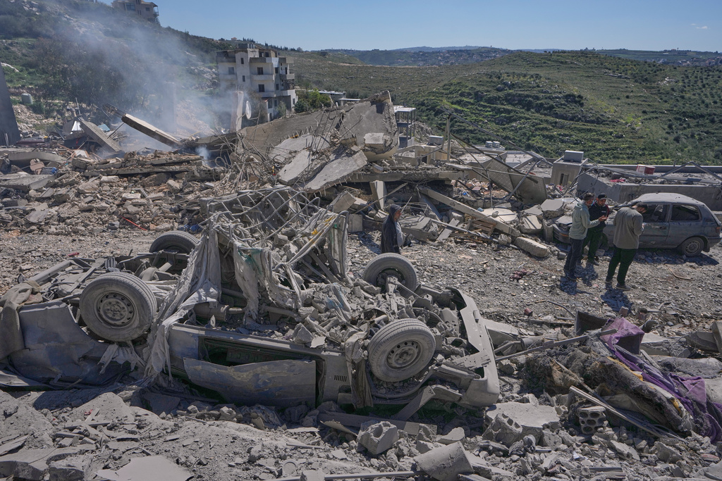 People check the site where Israeli airstrikes hit several houses in Sir al-Gharbiyeh village south Lebanon, Sunday, March, 8, 2026. (AP Photo/Mohammed Zaatari)