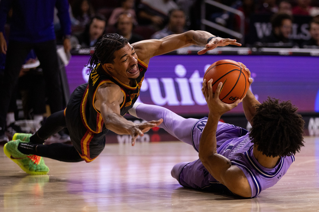 Southern California guard Chad Baker-Mazara, left, dives for the ball against Washington guard Desmond Claude, right, during the first of an NCAA college basketball game Saturday, Dec. 6, 2025, in Los Angeles. (AP Photo/Ethan Swope)