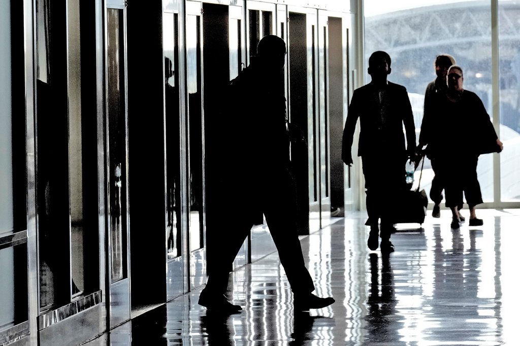 Arriving passengers are silhouetted as they get off a tram at the Tampa International Airport Tuesday, Nov. 11, 2025, in Tampa, Fla. (AP Photo/Chris O'Meara)
