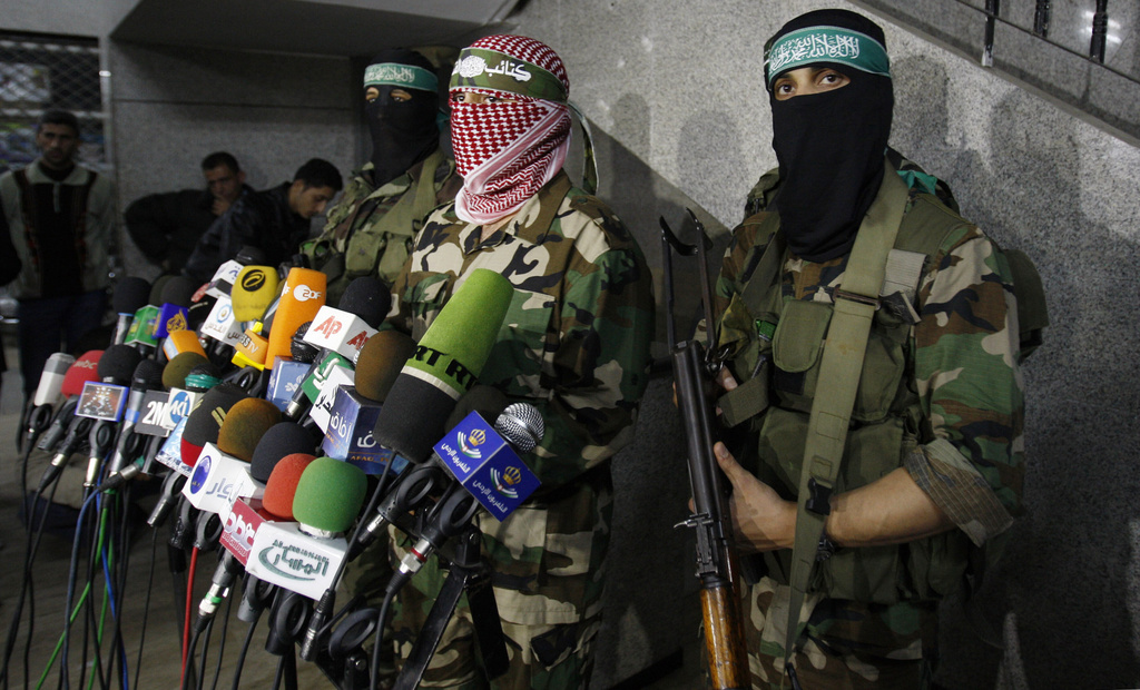 FILE - Abu Obeida, center, spokesman for the Qassam Brigades, the Hamas' military wing, holds a press conference in Gaza City on March 26, 2010. (AP Photo/Hatem Moussa, File)