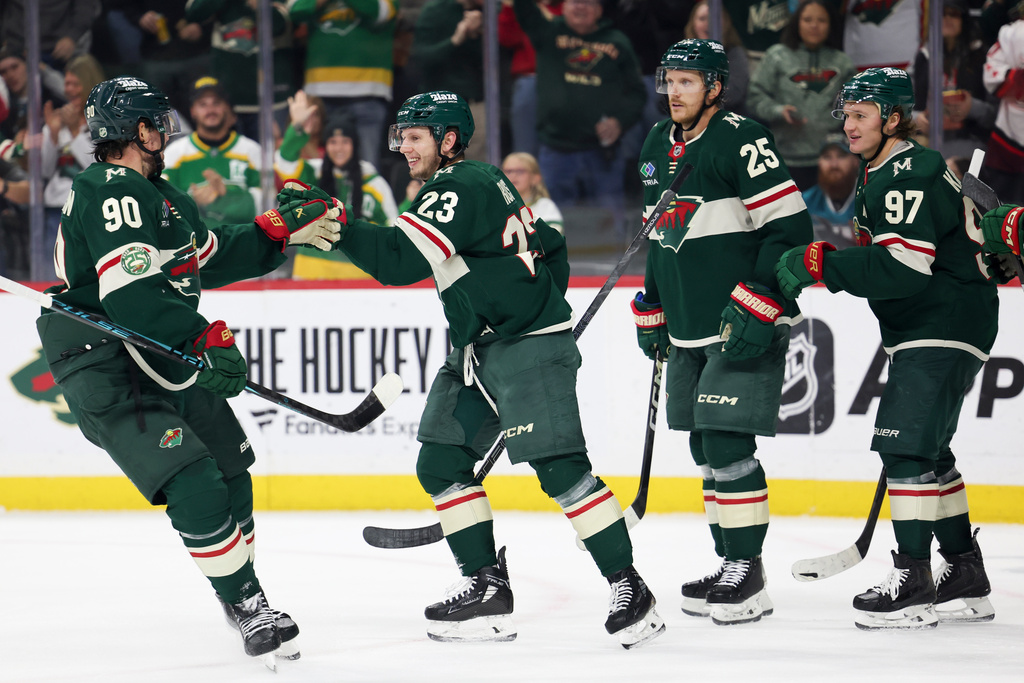Minnesota Wild center Marco Rossi (23) celebrates with his teammates after scoring a goal during the first period of an NHL hockey game against the San Jose Sharks, Sunday, Oct. 26, 2025, in St. Paul, Minn. (AP Photo/Ellen Schmidt)