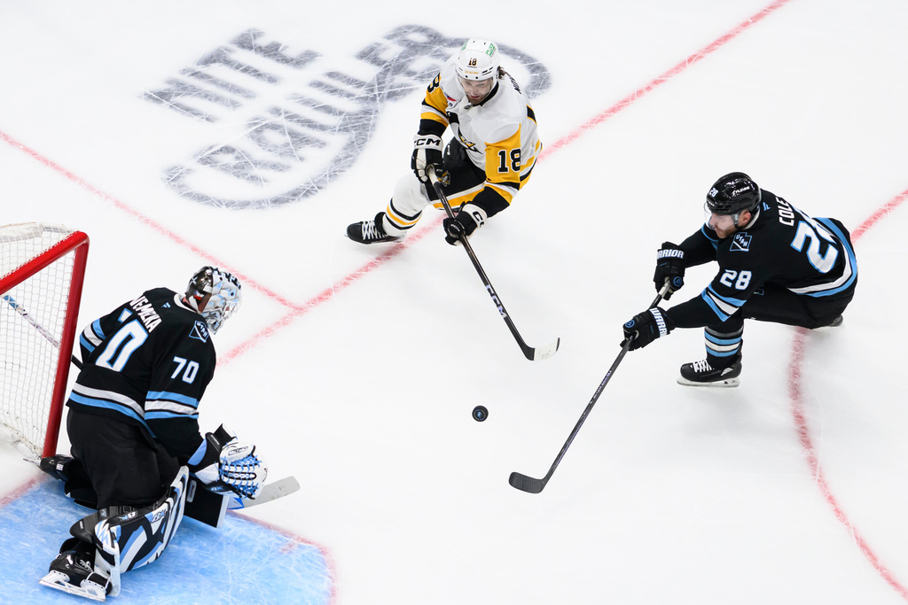 Pittsburgh Penguins center Tommy Novak (18) shoots the puck on net protected by Utah Mammoth goaltender Karel Vejmelka (70) during the first period of an NHL hockey game Saturday, March 14, 2026, in Salt Lake City. (AP Photo/Tyler Tate)