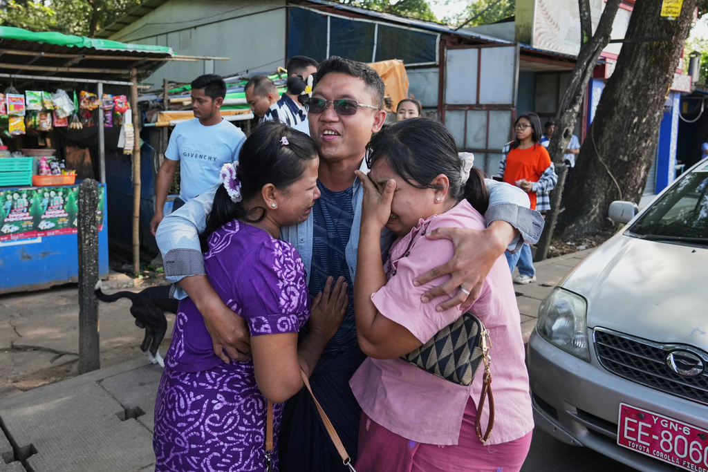 A man, center, released from Insein prison, is welcomed by family members in Yangon, Myanmar, Thursday, Nov. 27, 2025, after Myanmar's military rulers granted a mass amnesty ahead of elections. (AP Photo/Thein Zaw)