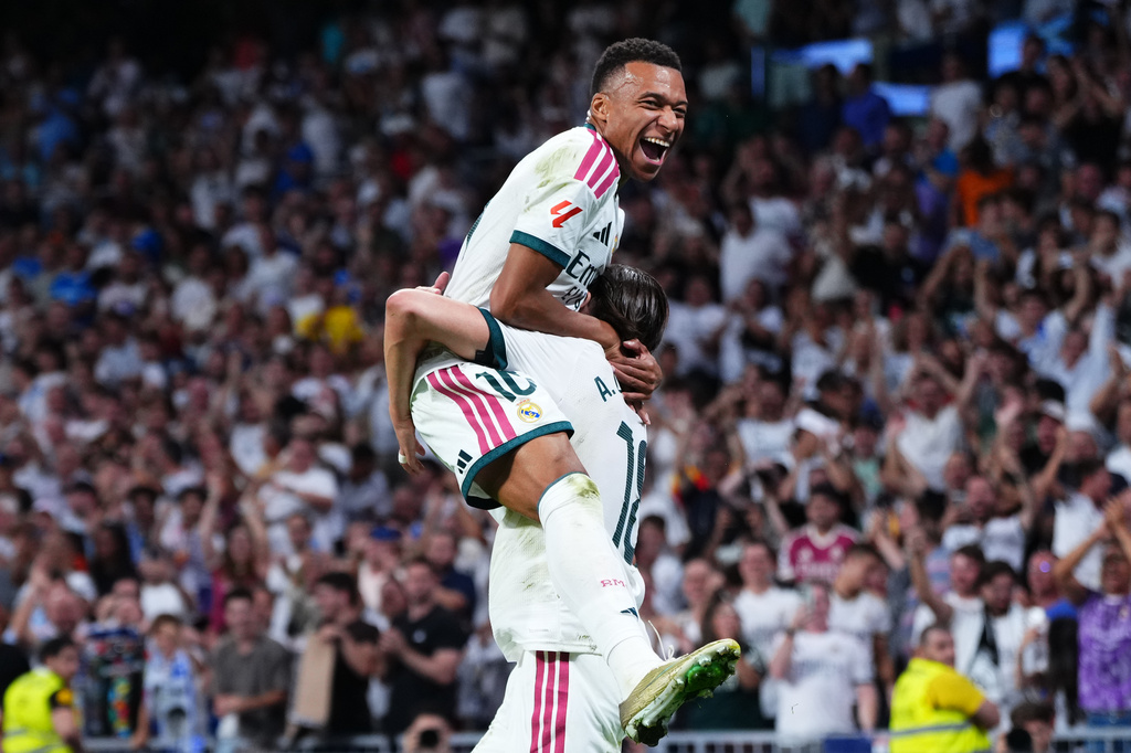 Real Madrid's Alvaro Carreras, bottom, is congratulated by Kylian Mbappe after scoring his side's 2nd goal during the Spanish La Liga soccer match between Real Madrid and Rayo Vallecano in Madrid, Spain, Saturday, Sept. 12, 2026. (AP Photo/Manu Fernandez)
