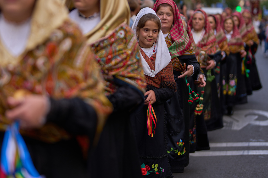 People in regional traditional costumes take part in the herding of sheep through central Madrid, Spain, as shepherds lead the animals through the streets in defense of ancient grazing and migration rights, Sunday, Oct. 19, 2025. (AP Photo/Manu Fernandez)