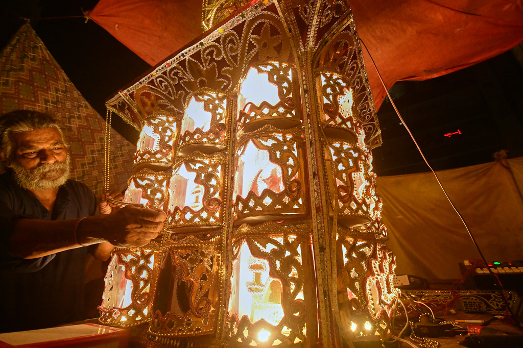 Raju Rathore, an artisan from Pakistani Hindu community, gives final touches to a replica of the mausoleum of Imam Hussain locally called 'Tazia', in preparation for the upcoming Ashoura, when Shiites Muslims mark the death of Hussein, at his home in Karachi, Pakistan, Tuesday, June 23, 2026. (AP Photo/Ali Raza)