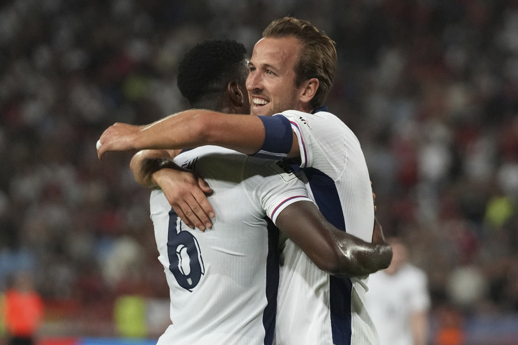 England's Marc Guehi, left, celebrates with England's Harry Kane after scoring his side's fourth goal during the World Cup Group K qualifying soccer match between Serbia and England, at the Rajko Mitic Stadium in Belgrade, Serbia, Tuesday, Sept. 9, 2025. (AP Photo/Darko Vojinovic)