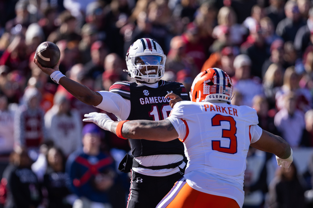 South Carolina quarterback Lanorris Sellers (16) throws under pressure from Clemson defensive end T.J. Parker (3) during the first half of an NCAA college football game, Saturday, Nov. 29, 2025, in Columbia, S.C. (AP Photo/Scott Kinser)