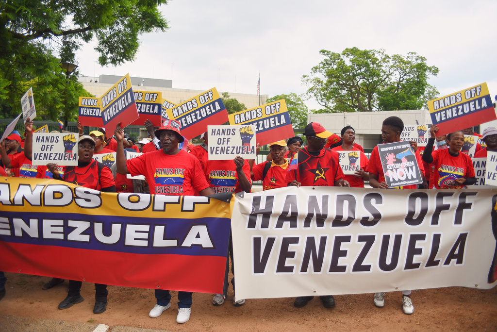 People hold placards and banners as they demonstrate outside the U.S. Embassy in Pretoria, South Africa, Thursday, Jan. 8, 2026. (AP Photo/Alfonso Nqunjana)