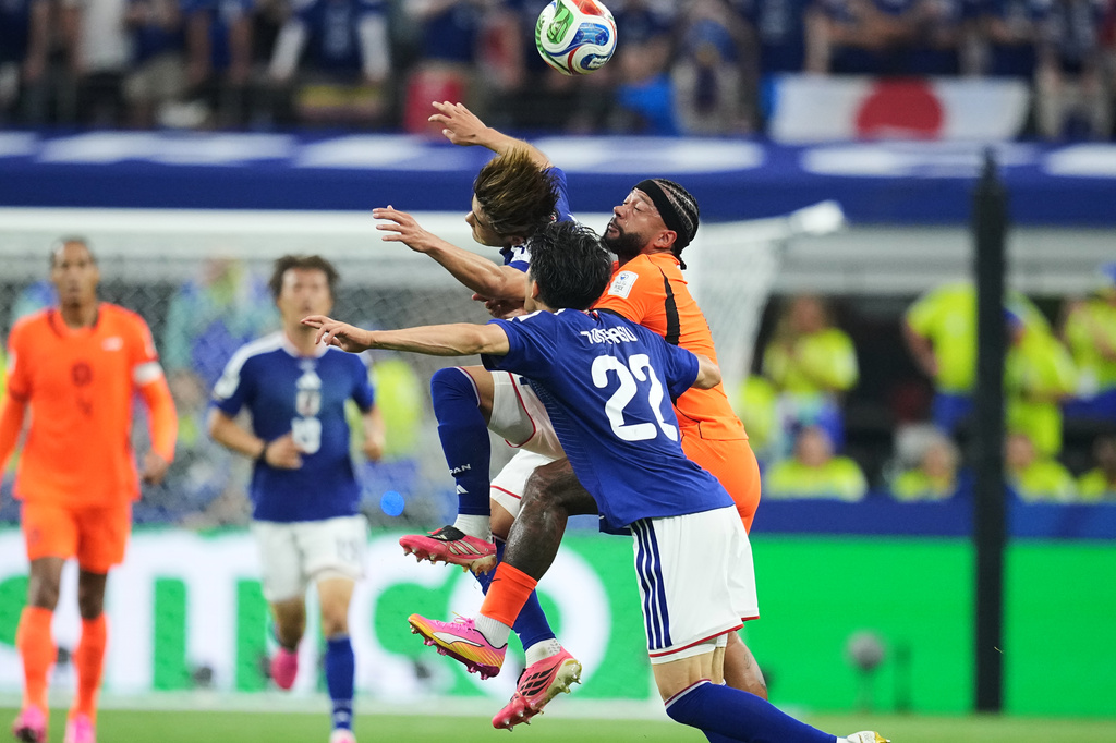 Japan's Takehiro Tomiyasu (22), Kaishu Sano, left, and Netherlands' Memphis Depay go for a header during a World Cup Group F soccer match in Arlington, Texas, near Dallas, Sunday, June 14, 2026. (AP Photo/Julio Cortez)